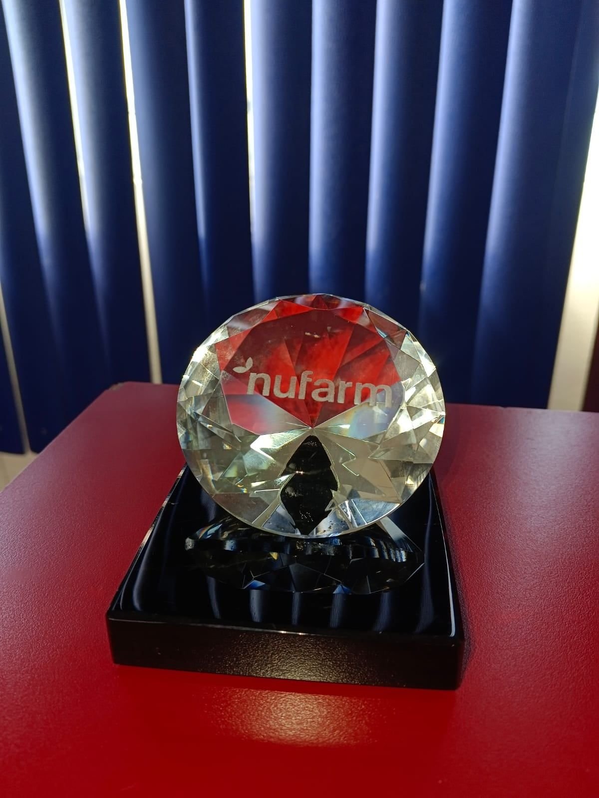 Diamante de cristal tallado con el logotipo de Nufarm sobre base negra