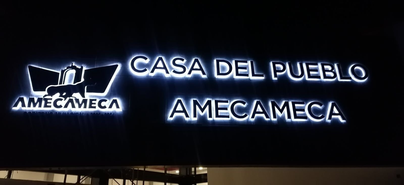 Letras 3D con iluminación LED blanca y logotipo de Amecameca en la fachada de la Casa del Pueblo, de noche