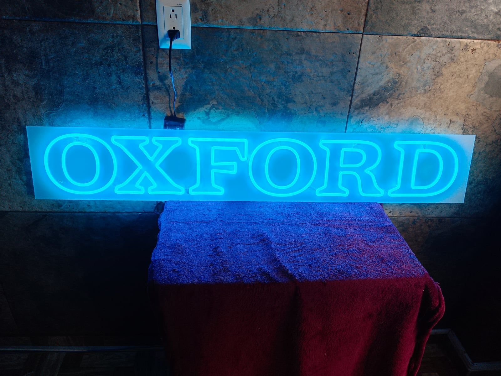 Letrero OXFORD en neón LED azul sobre placa de acrílico, encendido